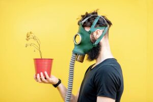 Atomgärten: Gärtner mit Strahlenkeule, Mann mit Gasmaske hält Pflanzentopf